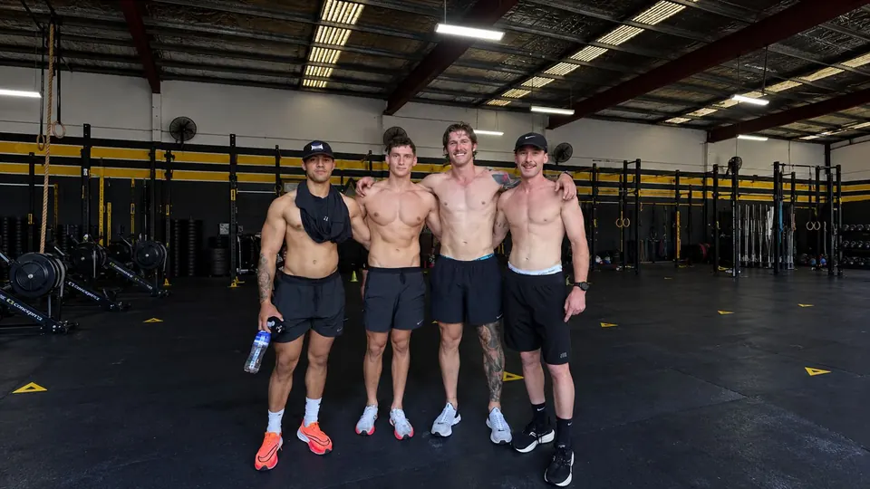 Cuatro atletas en el gimnasio después de entrenar