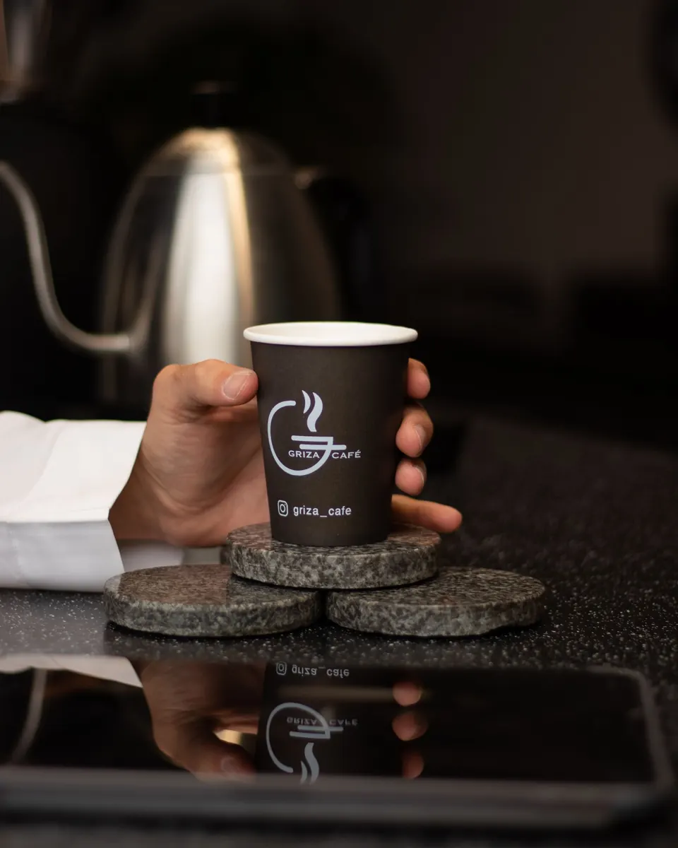 Barista sosteniendo un café para llevar