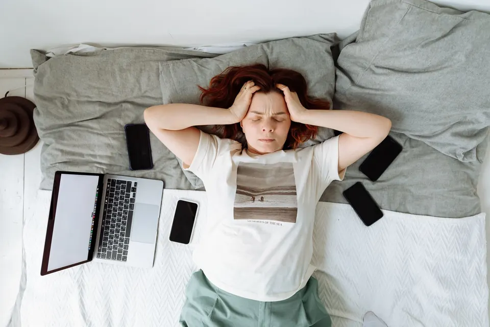 Mujer en la cama rodeada de dispositivos