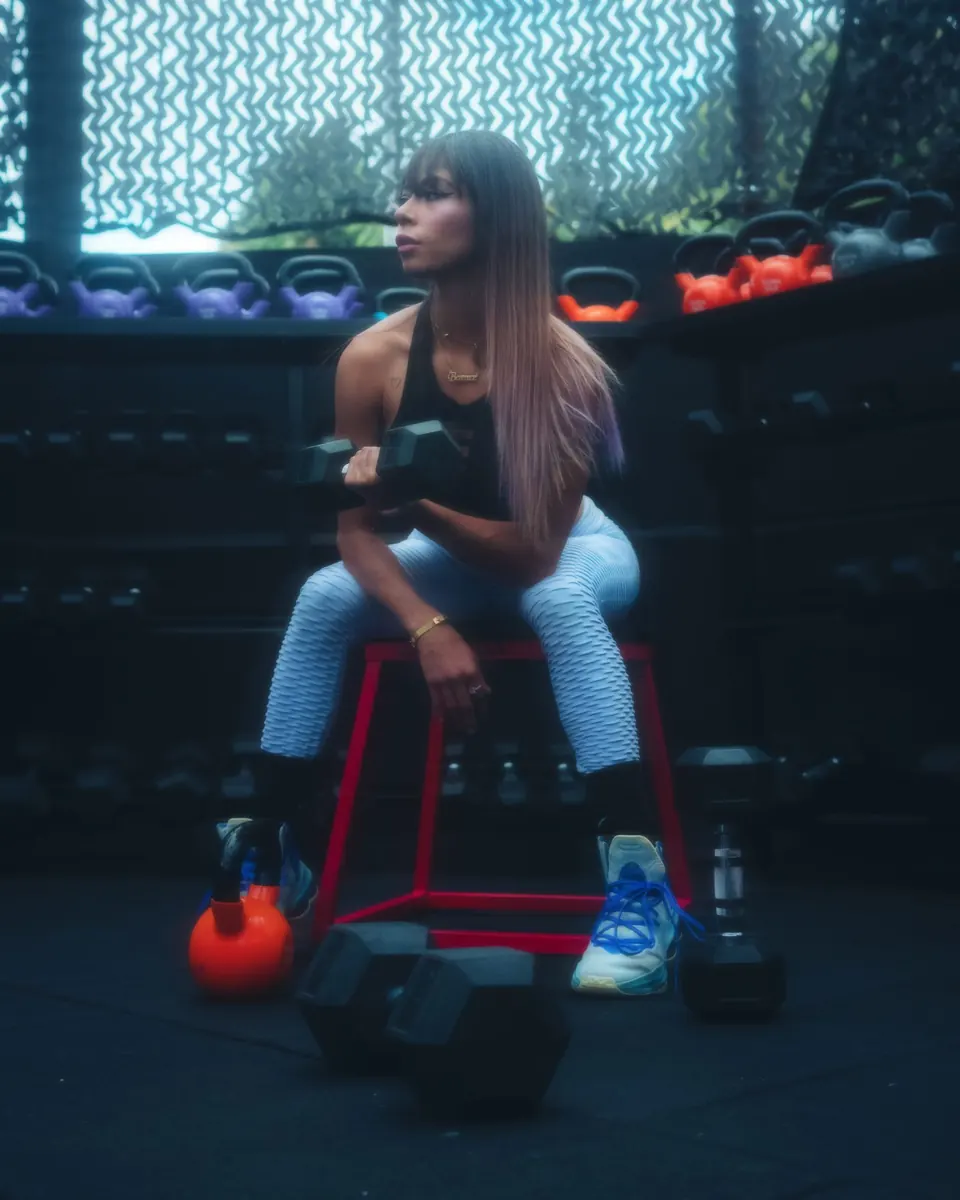 Mujer levantando mancuernas en el gimnasio